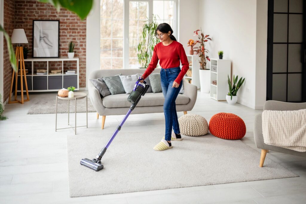Woman vacuuming modern living room with decor accents