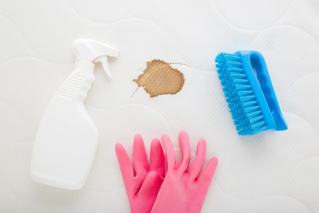 Close-up of cleaning tools including gloves and spray bottle